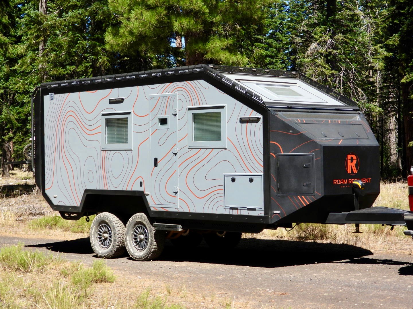 Curbside profile of the Baja Edition Bunk showing entry door and storage hatches