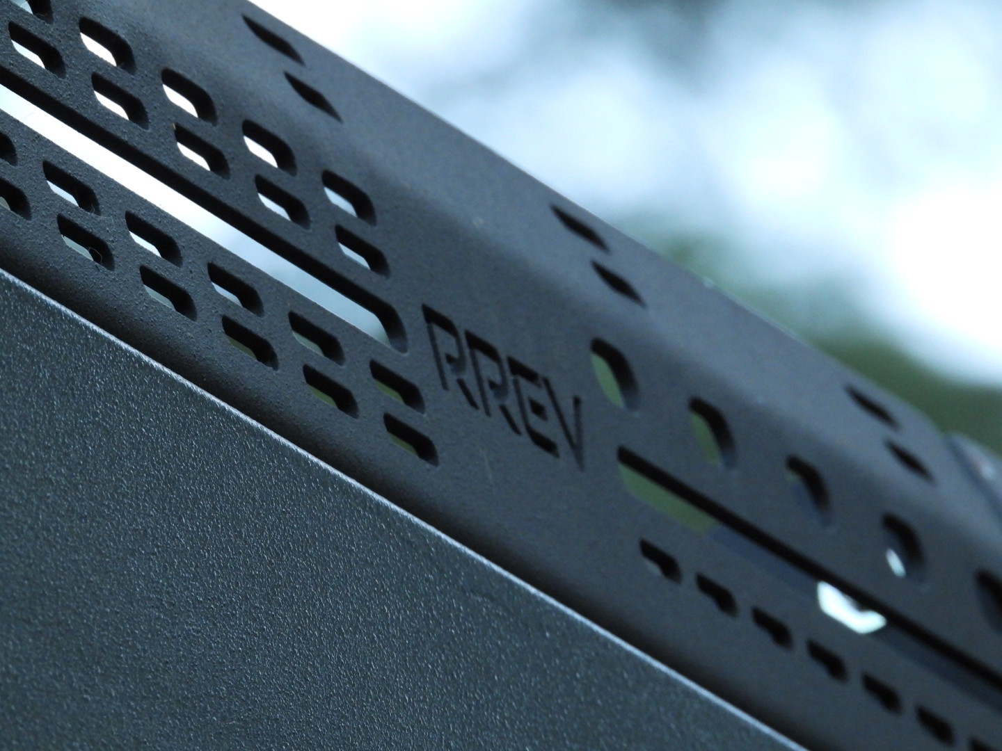 Perforated aluminum roof rack rail with the RREV mark cut into it